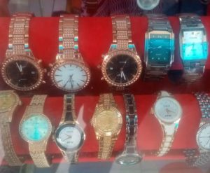The image features a collection of wristwatches with various metal finishes and face colors @ 25,000 each.